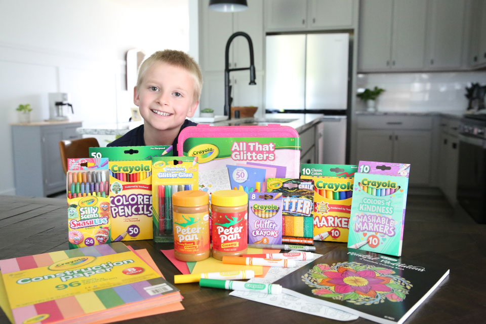 Photo of child smiling next to Crayola and Peter Pan Peanut Butter products